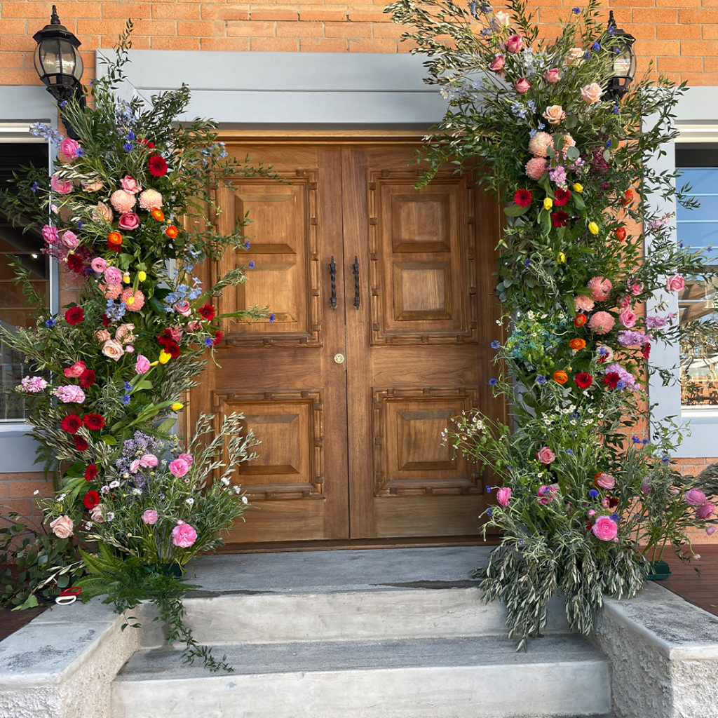 front door used as altar with colourful bridal flowers